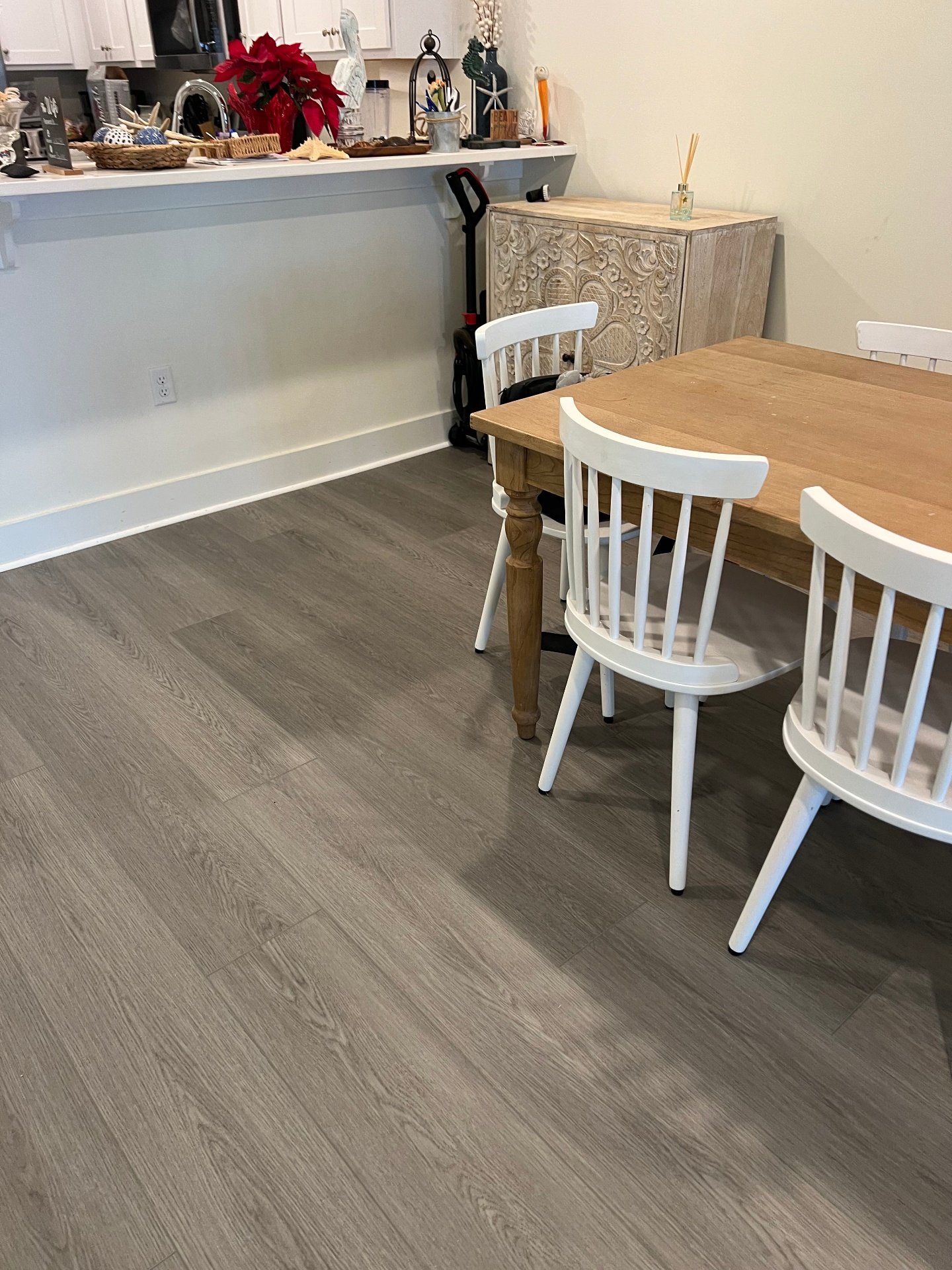 Coastal dining room luxury vinyl plank flooring installation with farmhouse table and beach cottage interior design