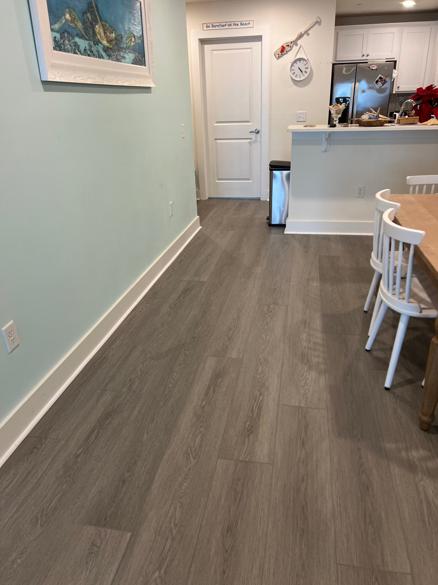 Beach house kitchen and dining area vinyl plank flooring with coastal decor and gray waterproof luxury vinyl planks