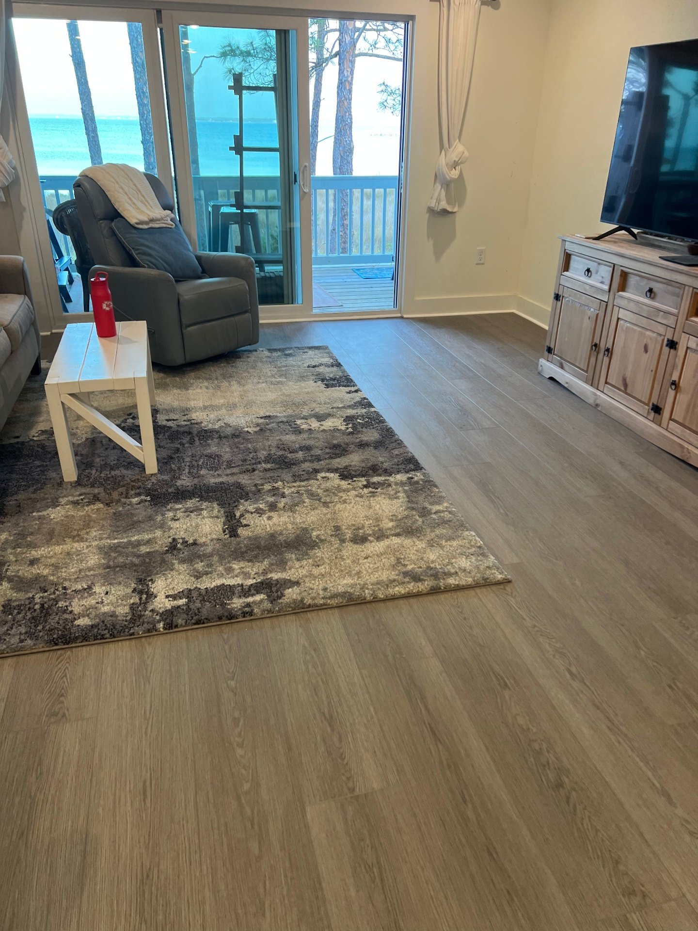 Oceanfront vacation rental vinyl plank installation with sliding glass doors to beach balcony and durable luxury vinyl flooring