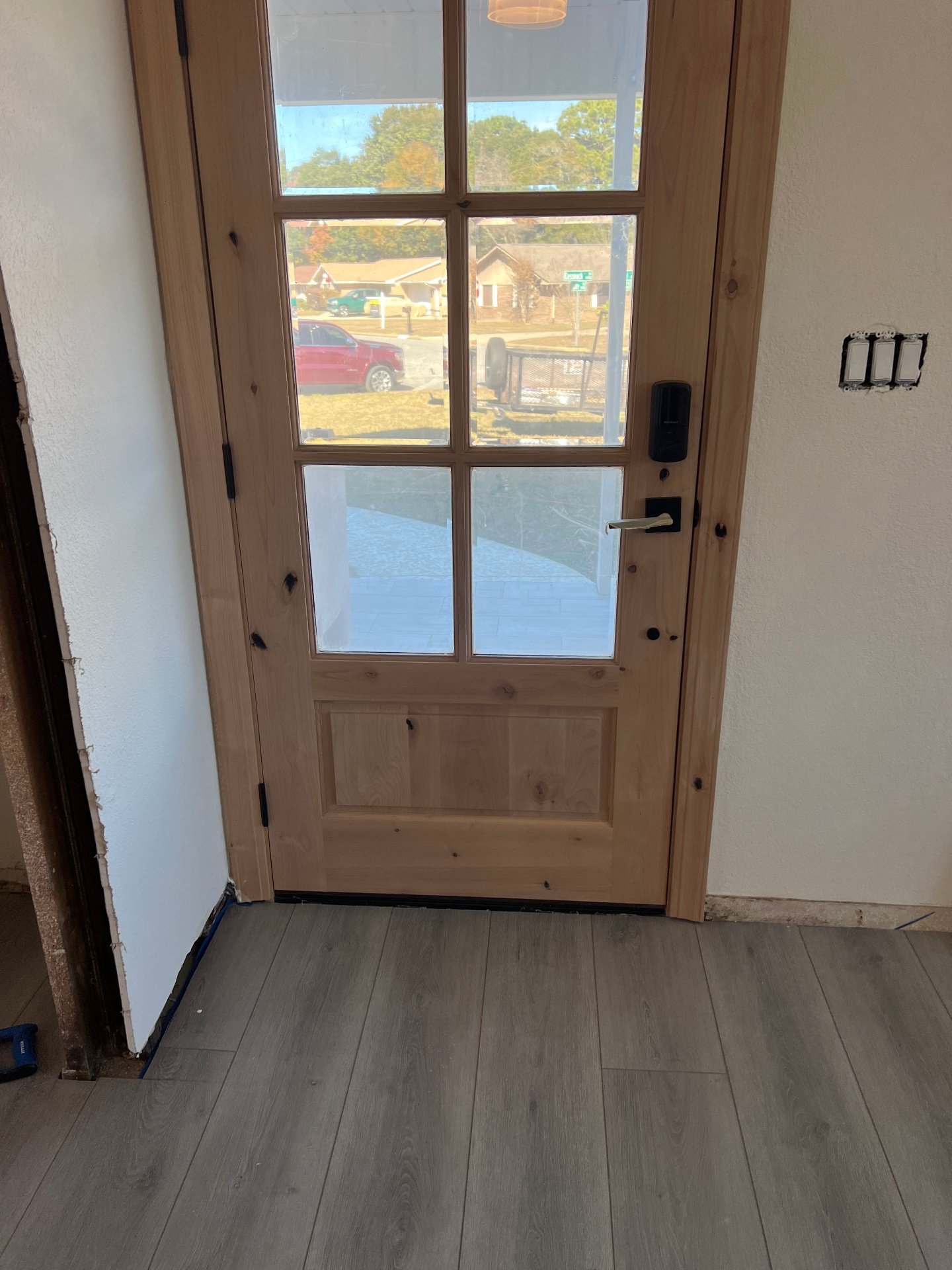 Front entry vinyl plank flooring with rustic wood door and gray-tone luxury vinyl planks for welcoming entryway