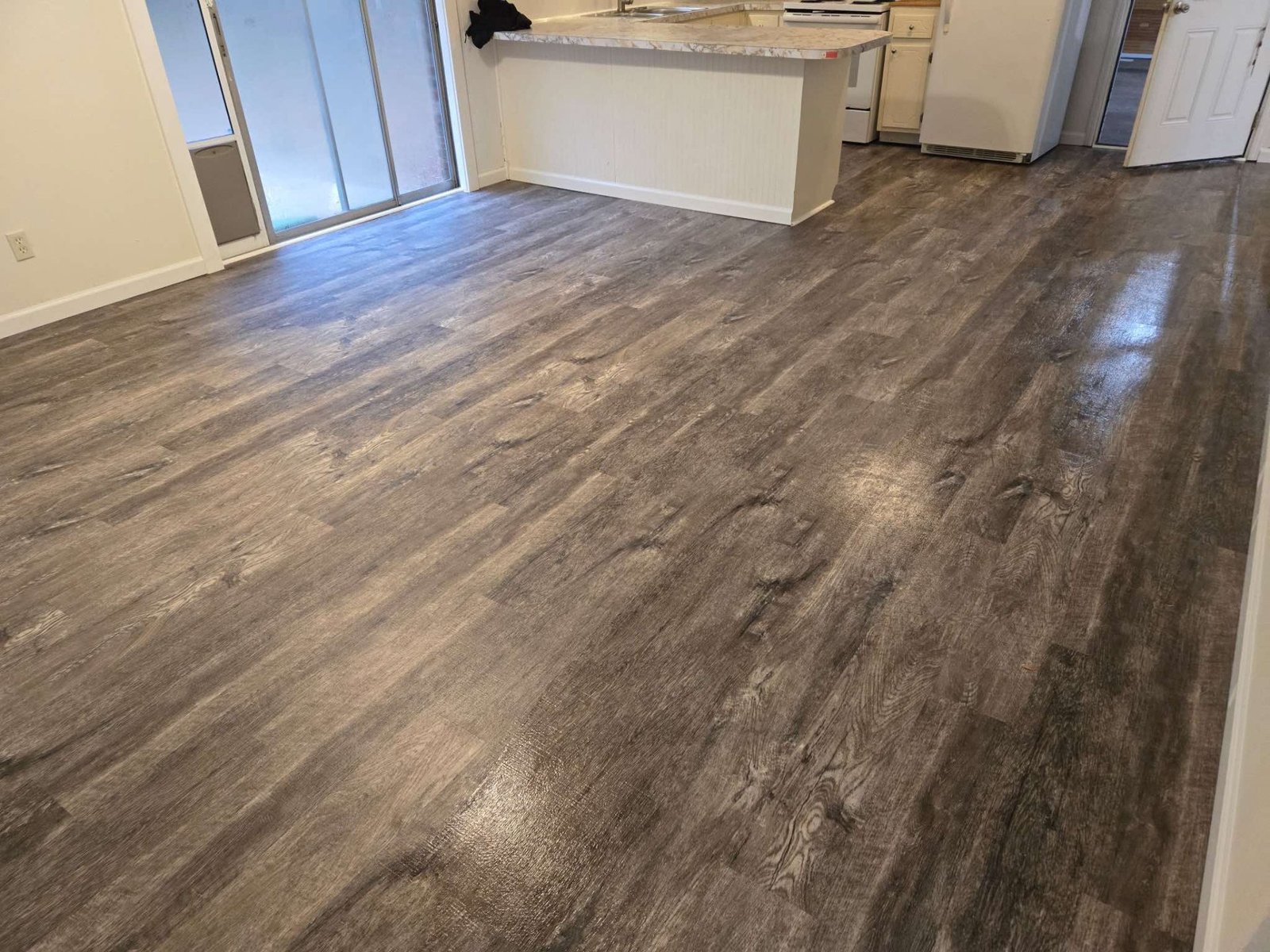 Waterproof luxury vinyl plank flooring installation in modern kitchen featuring durable scratch-resistant LVP with natural wood-look finish