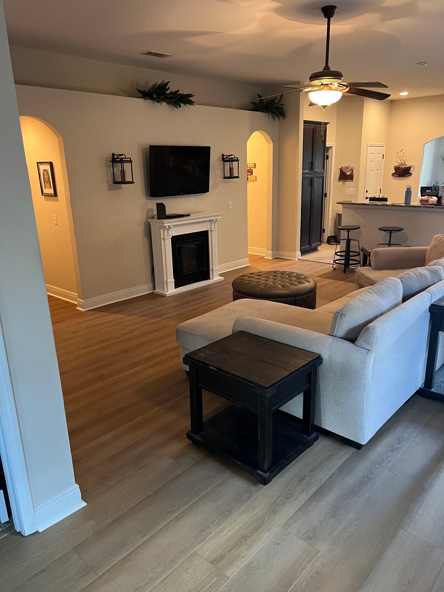 Professional luxury vinyl plank flooring installation in open concept living room kitchen and dining area featuring seamless waterproof LVP throughout modern home interior